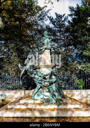 Eine Büste des französischen Künstlers Eugene Delacroix und eine bildhauerische Fantasy-Gruppe in den Gärten des Palastes von Luxemburg, Paris, Frankreich. Stockfoto