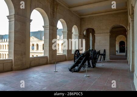 Einer der Außenkorridore im Armeemuseum mit alten Militärkanonen, Les Invalides Complex, Paris, Frankreich Stockfoto