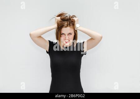 Eine sehr frustrierte und wütende Hassfrau, die auf weißem Hintergrund im Studio isoliert wurde Stockfoto