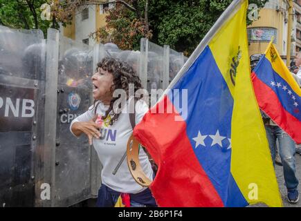 Caracas, Miranda, Venezuela. März 2020. Eine Frau ruft die Polizei an und bittet sie, die Konzentration passieren zu lassen. Die Demonstranten marschierten in die Innenstadt von Caracas, um die Kontrolle über die nationale Legislative wiederzuerlangen. Credit: Jimmy Villalta/ZUMA Wire/Alamy Live News Stockfoto