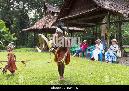 dh PNG-einheimische Tänzer ALOTAU PAPUA-NEUGUINEANISCHE Touristen, die die traditionelle Kultur des Dorfs beobachten, tanzen Stammbesucher Stockfoto