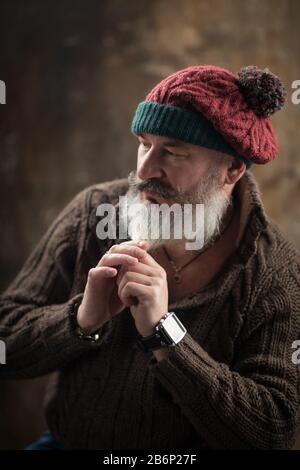 Studio-Porträt eines schönen, eleganten Mannes mit Bart und Schnurrbart in warmer Strickkleidung, selektiver Fokussierung Stockfoto