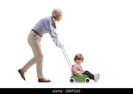 Mutter treibt ihre kleine Tochter in einem Holzspielzeug, isoliert auf weißem Hintergrund Stockfoto