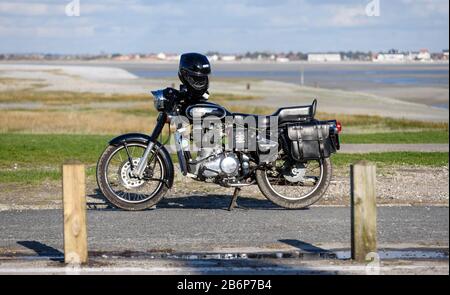 Royal Enfield Bullet 500 Motorrad in Le Hourdel (im französischen Departement Somme) mit der Bucht der Somme im Hintergrund geparkt. Stockfoto