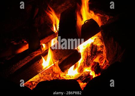 Makroschuss brennenden Brennholzes mit offener Flamme. Feuer geschlossen Stockfoto