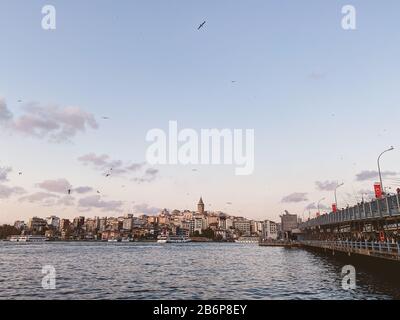 Die Galata-Brücke und der Galata-Turm am Bosporus in Istanbul, Türkei. Blick auf Istanbul mit vielen Möwen und bewölktem Himmel. Bezirk Karakoy und Stockfoto