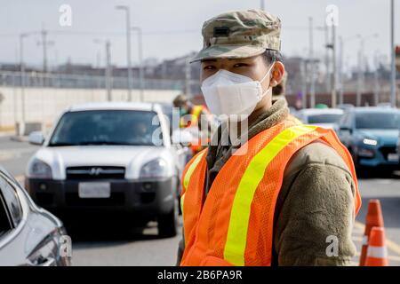 Soldat in der U.S. Army Garrison Humphreys (Camp Humphreys), Südkorea, 27. Februar 2020 Durchführung von COVID-19 (Coronavirus)-Screening-Verfahren. Stockfoto