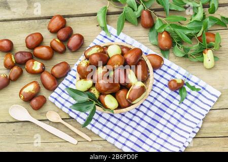 Korbkorb mit Früchten Ziziphus Real, Capiente, Jujube, chinesisches Datum, Capiinit, Jojoba, China-Datum (lat.Ziziphus jujujuba) und Holzlöffel auf einem n Stockfoto