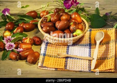 Korbkorb mit reifen Ziziphus echten Früchten, Kopfsteinpflaster, Unabi, Capiente, Marmalade, Capiinit, Jojoba, chinesische Datteln und Maulwurstblumen. Herbst noch Stockfoto