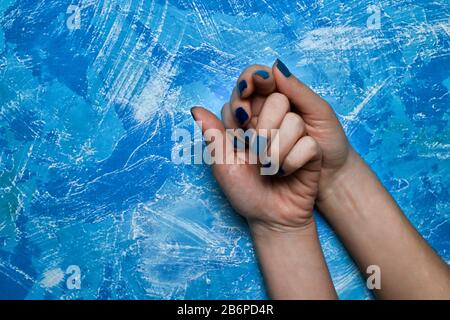 Blau-weiß mit weißen Linien Photophon, auf dem die Bürsten weiblicher Hände, abstrakt, Hintergrund, Pinselstriche sind Stockfoto