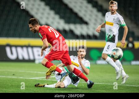 Mönchengladbach, Deutschland. März 2020. Tobias Strobl von Bor. Mönchengladbach (R) fordert Mark Uth von Köln beim Bundesligaspiel Borussia Mönchengladbach gegen den 1.FC Köln in der Saison 2019/2020 (Geisterspiel, Geisterspiel, Coronavirus) heraus DFL-Regelungen verbieten jede Verwendung von Fotos als Bildsequenzen und/oder Quasi-Video. Credit: Mika Volkmann/Alamy Live News Stockfoto