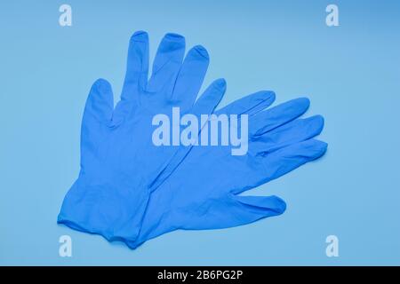 Blaue medizinische Handschuhe auf blauem Hintergrund Stockfoto