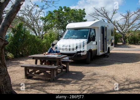 Tourist Reisen mit Wohnmobil Studium Karte auf seinem privaten Platz im Hauptcamp im Addo Elephant National Park, Südafrika Stockfoto