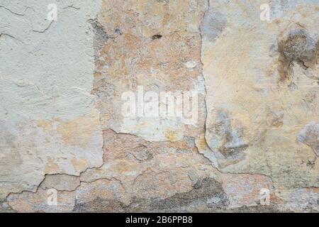 Texturierte grunge Hintergrund. Alte verputzte Wand mit einem Multilayer Beschichtung rissig. Grunge Textur mit einer tiefen Muster auf der weiß getünchten Wand Stockfoto