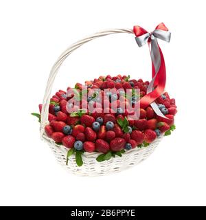 Großer Korbkorb mit reifen Erdbeeren und Blaubeeren auf weißem Grund. Stockfoto
