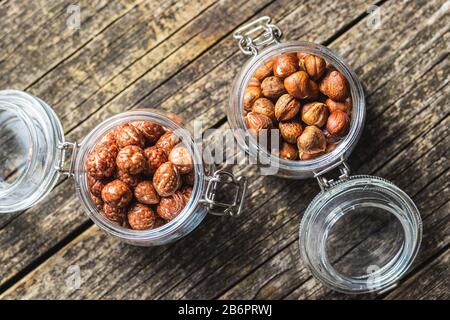 Haselnüsse mit Zuckervereisung im Mixbecher auf altem Holztisch. Draufsicht. Stockfoto