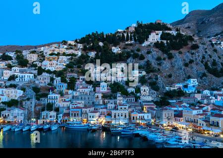 Blick über den Hafen in der Dämmerung Symi Town Symi Greek Islands Griechenland Stockfoto