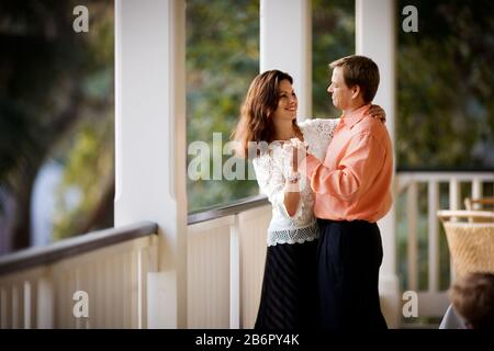 Lächelnd Mitte - erwachsene Paare tanzen zusammen auf einem Balkon. Stockfoto