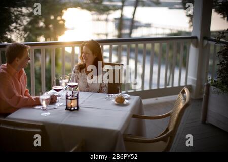 Gerne Mitte nach Paar in ein Restaurant im Freien Tisch sitzen. Stockfoto