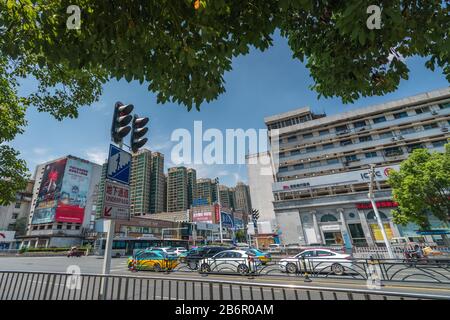 Yichang, China - August 2019: Eine Reihe von Autos, die an einem heißen Sommertag in der Stadt Yichang in der Provinz Hubei auf grünes Licht auf einer belebten Kreuzung warten Stockfoto