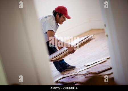 Männliche builder herauf alte Materialien aus ein Zimmer in einem Haus. Stockfoto