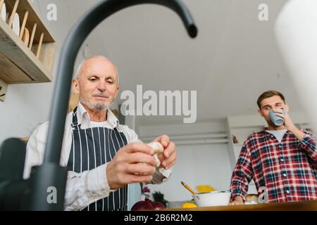Leitender Vater wasch Pilze in der Küche Stockfoto