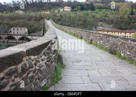 Die eindrucksvollen und berühmten Ponte della Maddalena von Lucca, die in einem alten mittelalterlichen Dorf in Borgo a Mozzano aus Backsteinen über einem Fluss erbaut wurde Stockfoto