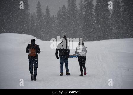 Baramulla, Jammu & Kashmir, Indien. März 2020. Touristen, die inmitten frischer Schneefälle im berühmten Skigebiet in Gulmarg laufen.Gulmarg Resort ist ein großer Skihügel, der mit einer Gondel bedient wird. Die Skisaison beginnt direkt nach Weihnachten und dauert je nach Schneeverhältnissen bis Ende März. In dieser Zeit verwandelt sich die verschlafene Stadt in einen Karneval von Skifahrern aus Russland, Australien, Neuseeland, Europa und den USA. Kredit: Idrees Abbas/SOPA Images/ZUMA Wire/Alamy Live News Stockfoto