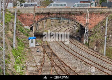 Istanbul, Türkei - 11. Februar 2020: Verrostende Bahnschienen und eine alte Steinautobrücke über sie. Stockfoto