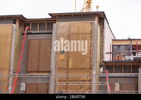 Neues, im Bau befindliches, flaches Wohnhaus mit roten Rohren und überdachten Fensterabschnitten: Kopenhagen, 27. Februar 2020. Stockfoto