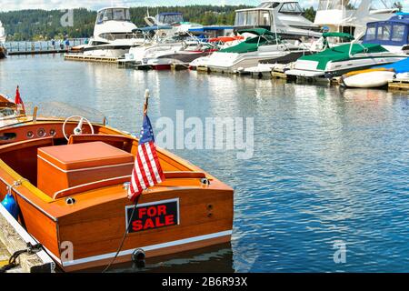 Ein Schild "Zum Verkauf" auf einem alten Holzboot in einem Jachthafen am Lake Coeur d'Alene in Coeur d'Alene, Idaho, USA. Stockfoto