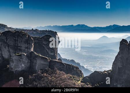 Blick auf das Unesco-Denkmal Meteora, die Berge, das Wahrzeichen der Griechen, sonniges Wetter, Nebel, Dunst über einem Tal Stockfoto