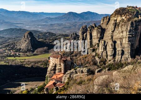 Luftbild des Klosters Rousanou und atemberaubendes malerisches Tal und Wahrzeichen von Meteora bei Sonnenuntergang, Kalambaka, Griechenland, Schatten, verdreht Stockfoto