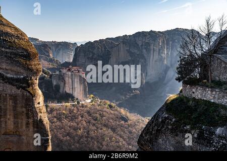 Luftbild des Klosters Rousanou und atemberaubendes malerisches Tal und Wahrzeichen von Meteora bei Sonnenuntergang, Kalambaka, Griechenland, Schatten, verdreht Stockfoto