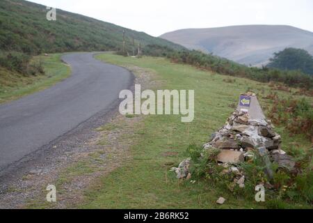 Die asphaltierte Straße nach Orrison France entlang des Camino de Santiago de Compostela und der Wegweiser Stockfoto