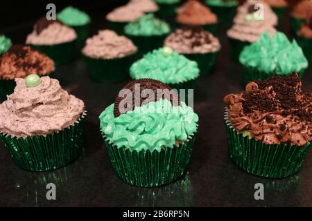 Drei grün Dekorierte Cupcakes zum Geburtstag oder zur Veranstaltung mit Plätzchen zerbröckeln und aufschäumen Stockfoto