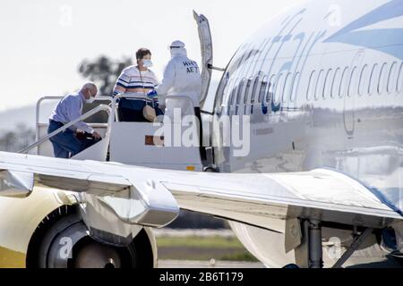 Oakland, Vereinigte Staaten. März 2020. Medizinisches Personal unterstützt Passagiere vom Kreuzfahrtschiff Grand Princess an Bord eines gecharterten Flugzeugs am Oakland International Airport in Oakland, Kalifornien am Mittwoch, 11. März 2020. Foto von Peter DaSilva/UPI Credit: UPI/Alamy Live News Stockfoto