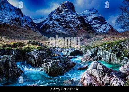 Frühling in Glencoe, Hochland, Schottland, Großbritannien mit Blick auf die drei Schwestern und den Fluss Coe. Stockfoto