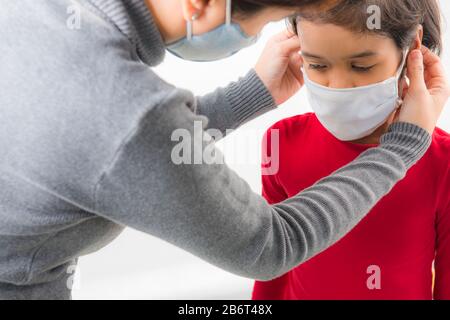 Familie mit Kindern in Gesichtsmaske auf weißem Hintergrund. Mutter und Kind tragen während des Ausbruchs des Coronavirus einen Gesichtsbefall. Covid-19 Coronavirus Konzept. Virus an Stockfoto