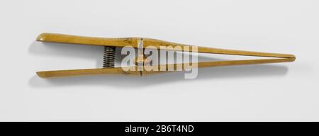 Handschoenrekker van gelakt hout Handschoenrekker van gelakt hout, met tussen de twee scharen een metalen veer. Hersteller : houtsnijder: AnoniemPlaats Herstellung: Nederland dating: CA. 1885 - ca. 1950 Physikalisches Kenmerken: Hout, Lak, Metaal-Material: Geheel: Hout Geheel: Lak veer: Metaal Techniek: Snijden / Lakken Abmessungen: Geheel: H 31 cm. × b 3 cm. × d 4,5 cm. Stockfoto