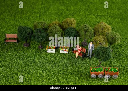 Miniaturspielzeug einer Frau und eines Mannes, umgeben von Bäumen in einem Park Stockfoto