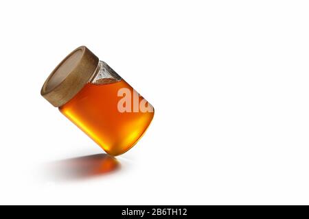 Frischer Honig mit Holzdeckel auf einem Glasbehälter. Folgen des zentralen dominanten Gesetzes im Hintergrund des Whitepapers. Stockfoto
