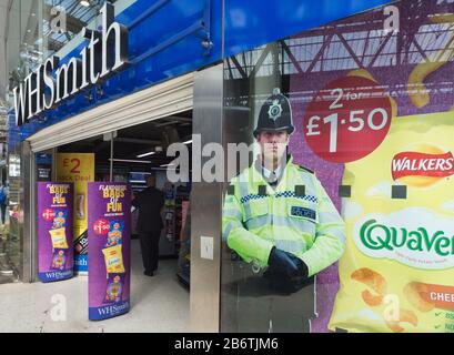 Im Bahnhof Waterloo steht ein Pappausschnitt eines Polizisten hinter dem Fenster von WH Smith als Abschreckung für die Kriminalität. Stockfoto