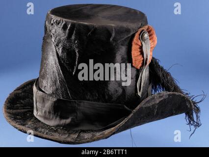 Hoed van Vrouw Schoonderwoert, marktster Zuidhollandse Schutterij 1830-1831, buitenmodel Headress lackiert schwarzen Filz, rettete eine Seite der Grenze. Hut bedeckt mit Rollen, runder Hut schwarz oder grünes Band oben gelagert von Corpus orange Kakade mit weißer Metallfahne und Knopf, wobei: Eine Granate, im Band um die Ecke und schwarze oder grüne Straußenfeder in einem weißen Papier: No.93 EINE Hutfrau Schoonderwoert Marktstar in der Dept ZH Miliz. (?). Innen Lederrand, innen Stoff. Auf dem untersten Schild mit königlichen Armen, darunter Text: Willem Pauwels und Sohn Hoeden-Hersteller von Stockfoto