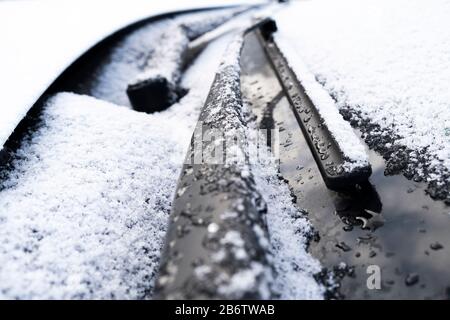 Gefrorener Scheibenwischer und Glas im Auto. Tiefgefrorene Windschutzscheibe schließen. Gefrorenes weißes Auto im Winter. Eis an der Frontscheibe eines Autos. Stockfoto