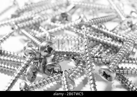Selbstschneidende Metallschraube im Hintergrund. Makroschuss einer selbstschneidenden Schrauben. Hintergrund der Schraube. Selbstbohrende Befestigungselemente. Muster der Stahlschrauben. Werkzeug Stockfoto
