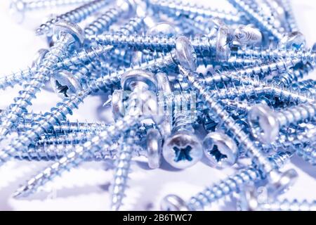 Selbstschneidende Metallschraube im Hintergrund. Makroschuss einer selbstschneidenden Schrauben. Hintergrund der Schraube. Selbstbohrende Befestigungselemente. Muster der Stahlschrauben. Werkzeug Stockfoto
