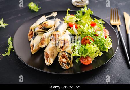 Pfannkuchenwoche. Shrovetide. Gerollte Pfannkuchen gefülltes Hühnerfleisch und Gemüse. Herzhafte Krepes. Stockfoto