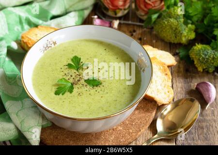 Vegetarisches Gericht. Köstliche Brokkoli Creme-Suppe mit Knoblauchkroutonen auf einem rustikalen Tisch. Stockfoto