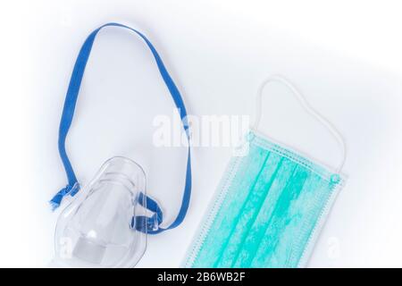 Medizinischer Ultraschall-Inhalator oder Vernebler Sauerstoffmaske und hygienische Gesichtsmasken auf weißem Hintergrund, Kopierraum Stockfoto
